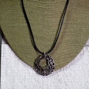 Silvertone swirl round Pendant on black cord necklace